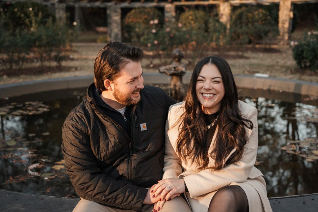 Couple laughing together during Raleigh Rose Garden engagement session portraits.