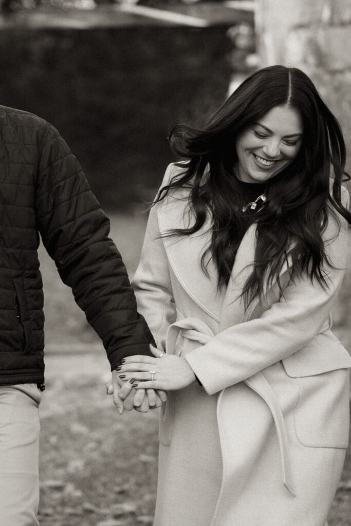 Just engaged couple holding hands and walking through Raleigh Rose Garden at sunset.