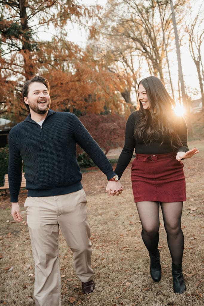 Just engaged couple laughing and walking together at Raleigh Rose Garden in North Carolina.