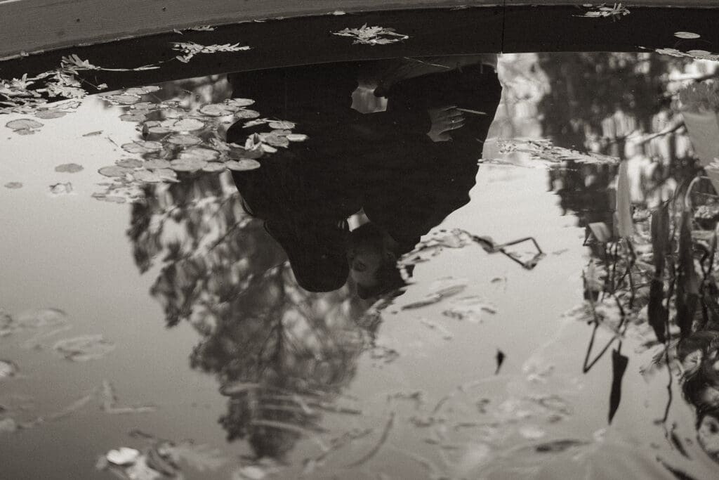 Reflection of engaged couple in fountain water at Raleigh Rose Garden proposal.