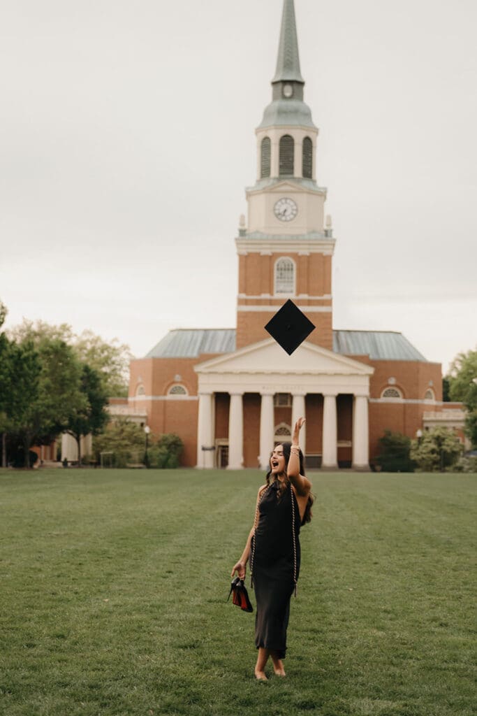Wake Forest senior tossing graduation cap in front of Wait Chapel during graduation photo session