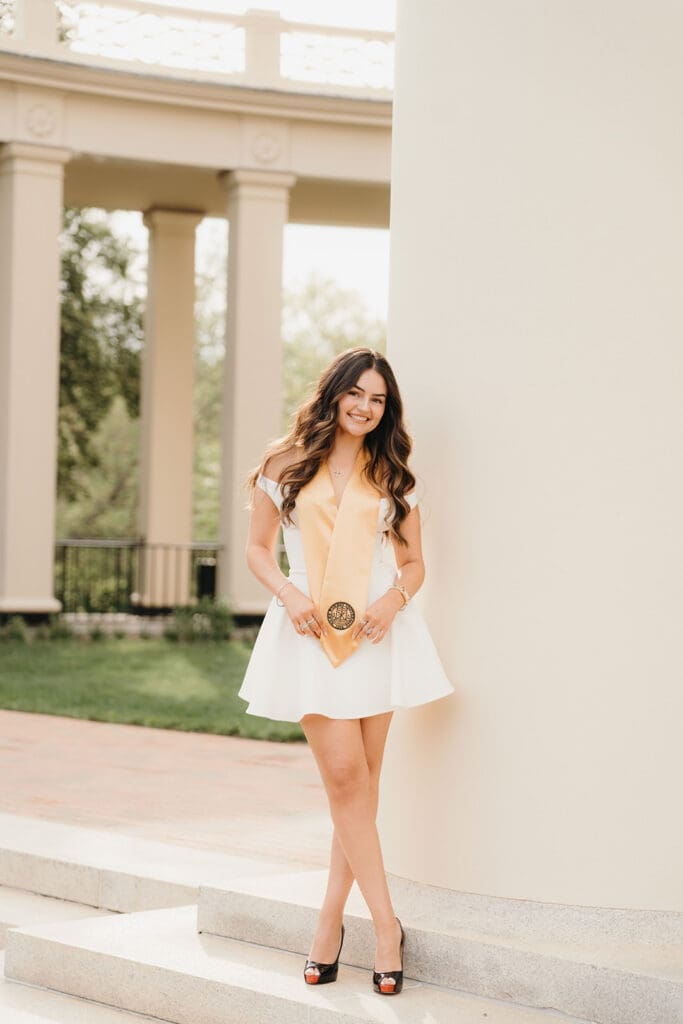 Wake Forest graduation photo of senior holding diploma in front of classic campus architecture