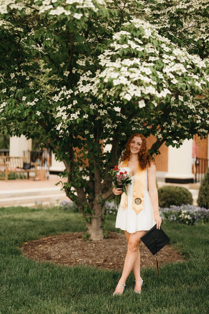 Wake Forest senior portrait under blooming tree on campus during graduation season