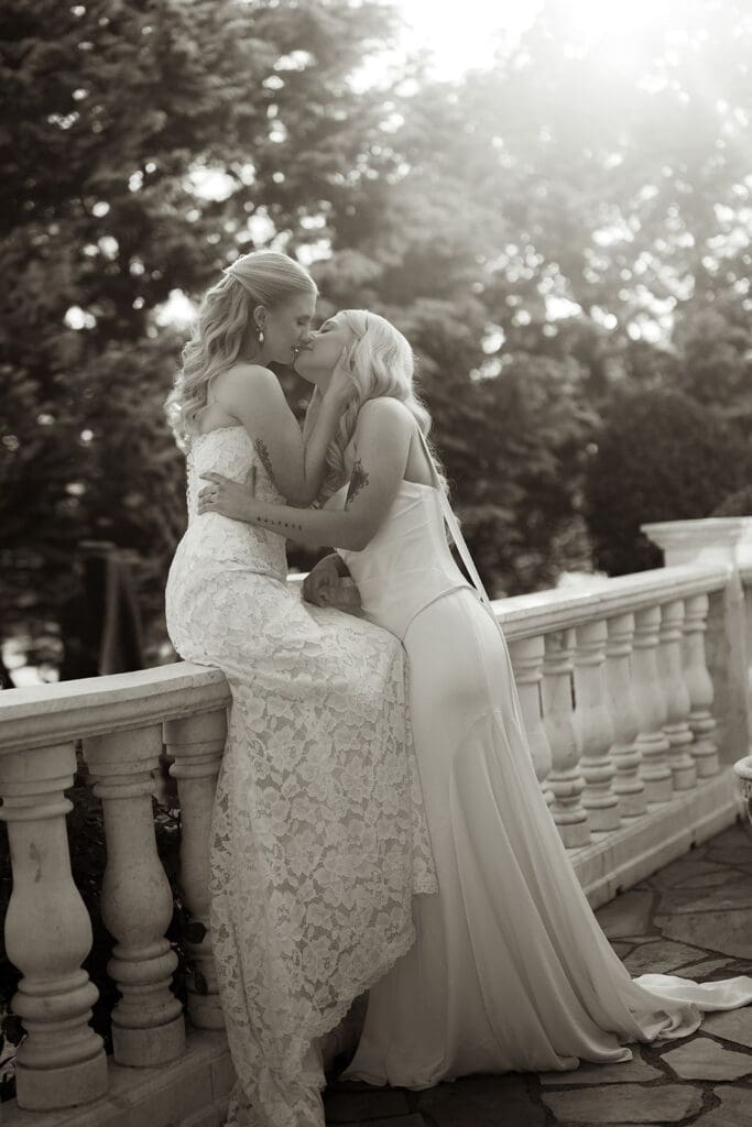 Same-sex couple sharing a kiss during editorial wedding portraits at Le Château du Coeur.