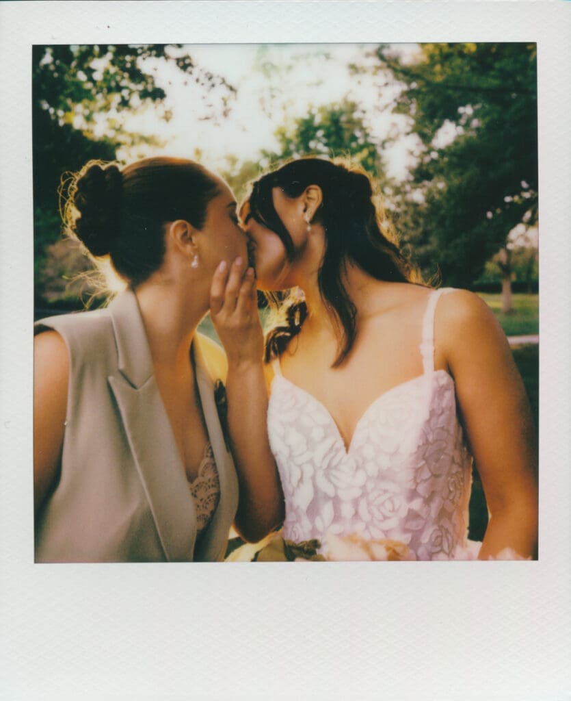 Polaroid wedding portrait of a couple sharing a kiss.