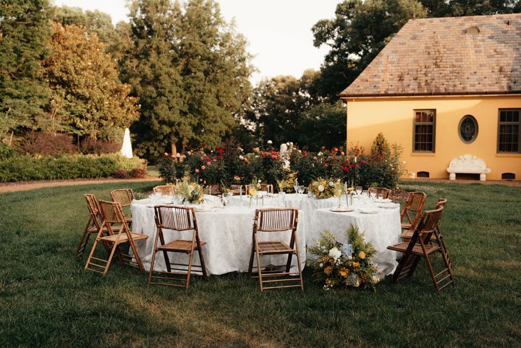 Garden reception design with blue linens and floral centerpieces at Le Château du Coeur.