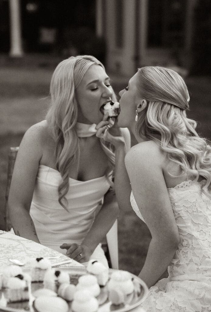 Brides sharing dessert during editorial wedding reception portraits.