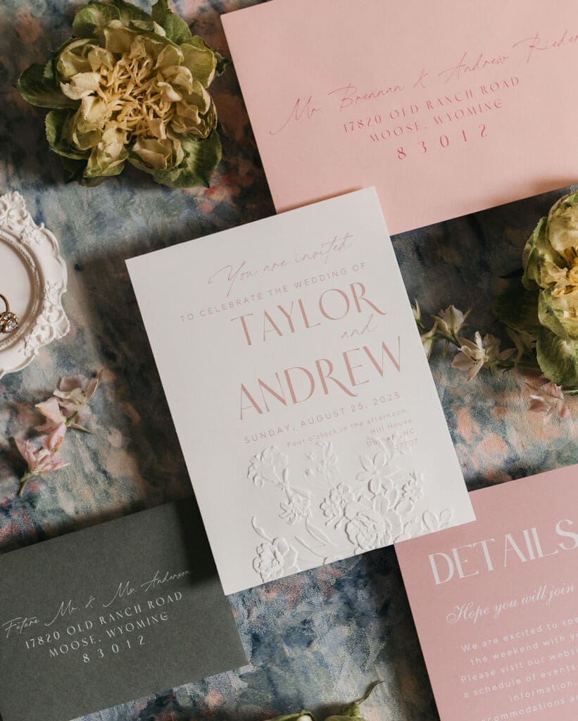 Flat lay of custom wedding invitations and embossed stationery for a garden wedding.