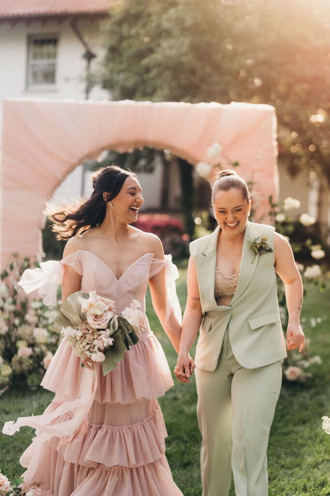 Joyful wedding portrait of a couple walking through the garden at Hill House.