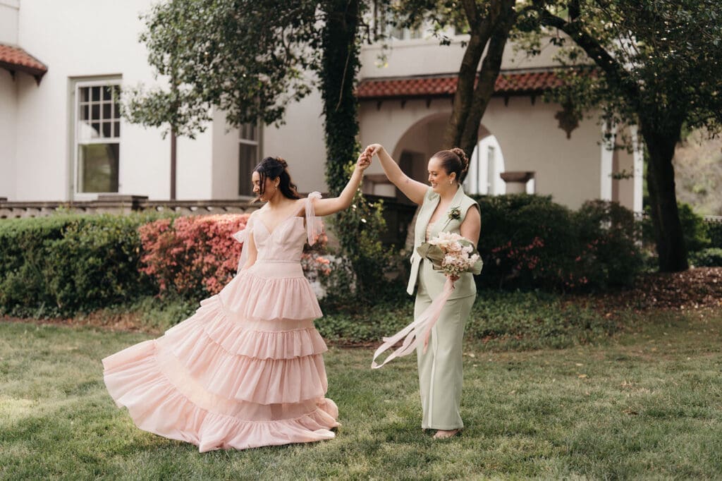 Couple twirling together on the lawn during a Hill House wedding editorial.