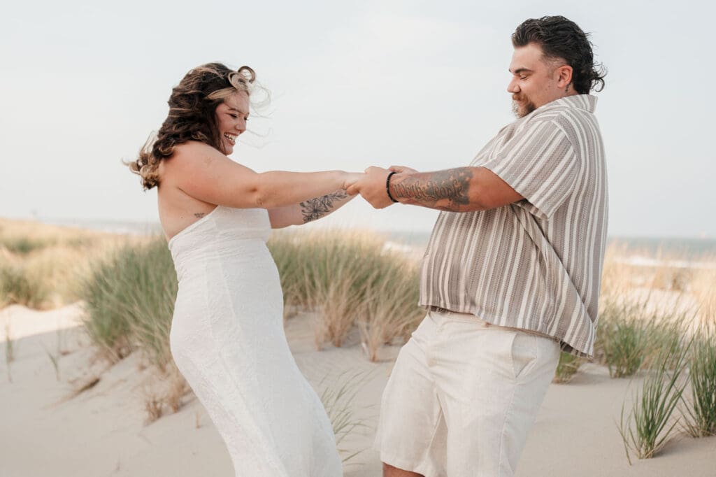 Couple holding hands and twirling on beach