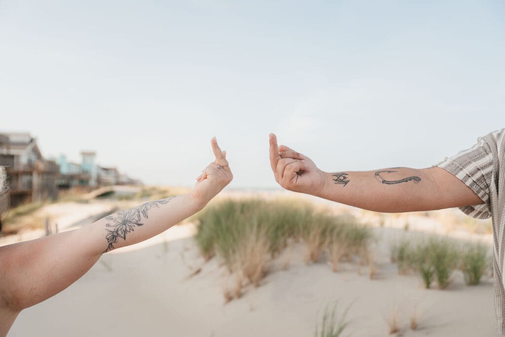 Close up of hands giving each other the middle finger.