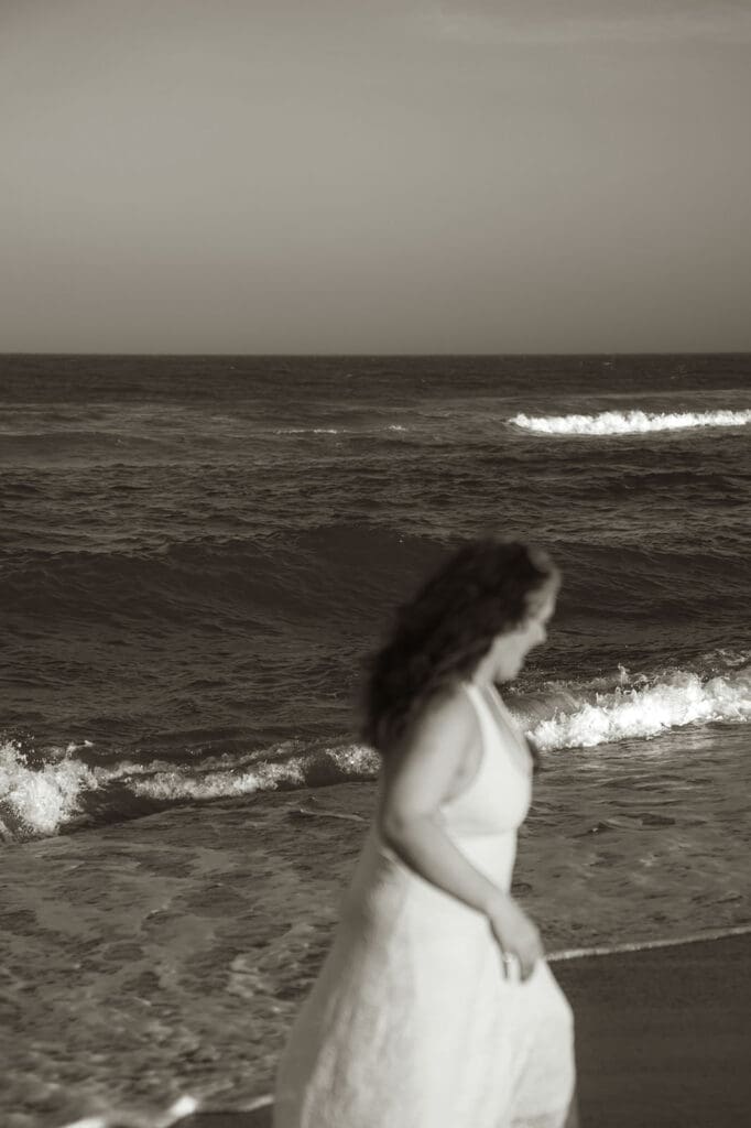 photo of ocean with girl out of focus in the foreground.