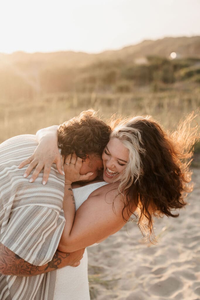 couple at sunset kissing neck on avon beach